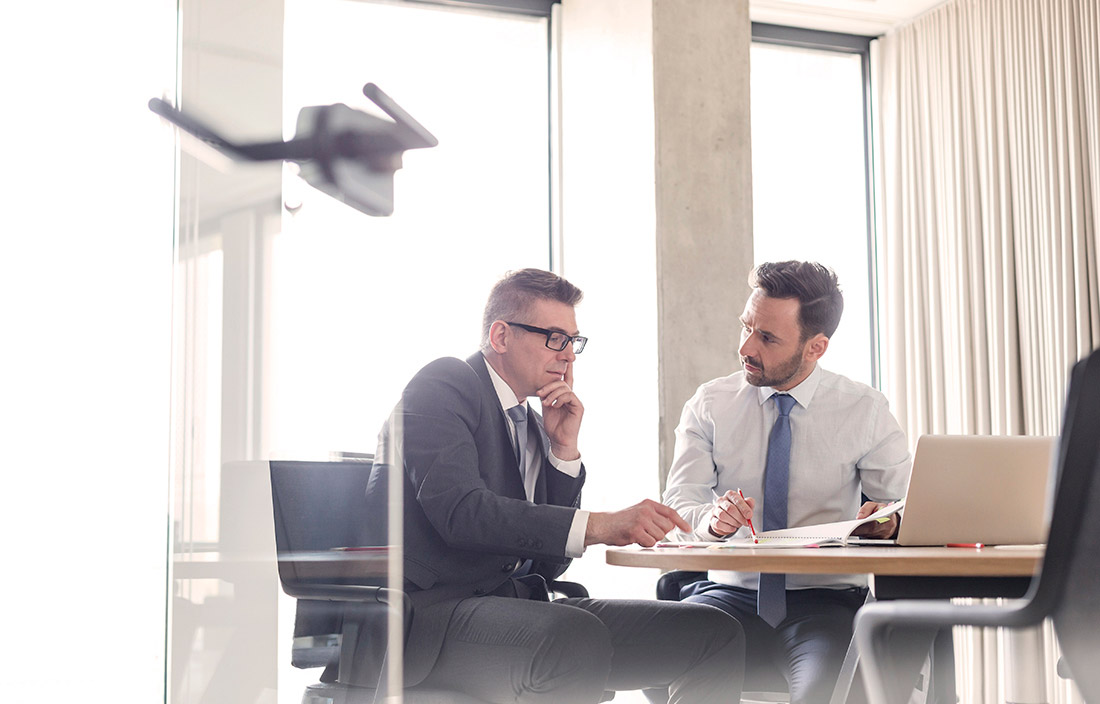Two business professionals reviewing their loan covanant in an office.