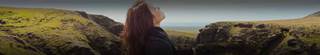 A woman standing in nature looking up into the sky.
