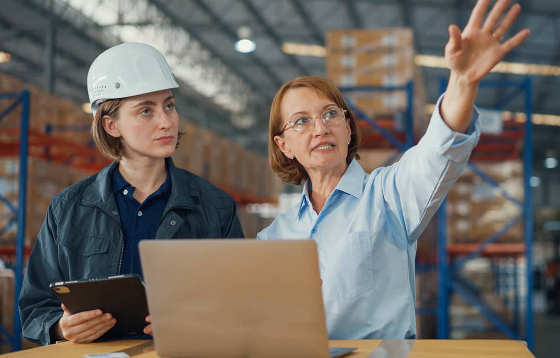 Manufacturers in a factory discussing data and analytics.