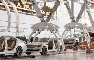 Cars on a factory assembly line.